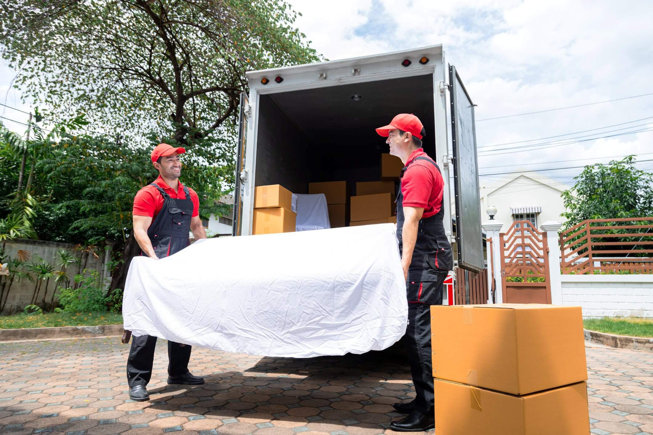 Movers loading truck with bed and boxes.